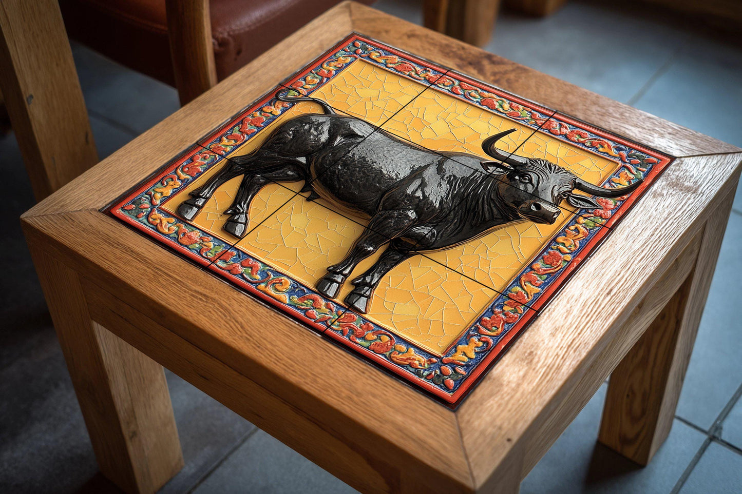 Ceramic mural of a majestic bull: glossy black figure on a gold mosaic background with an ornate border, symbol of strength and legacy.