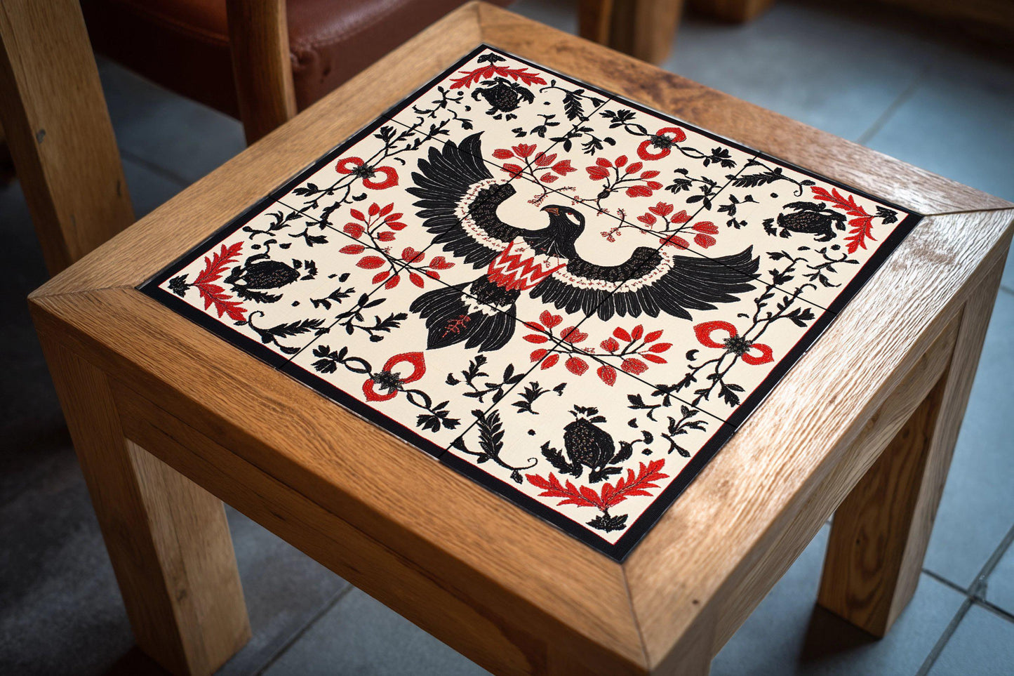 Ceramic mural of eagle and vine: Albanian folk motif with symmetry in black and red, artistic mosaic inspired by cultural heritage.