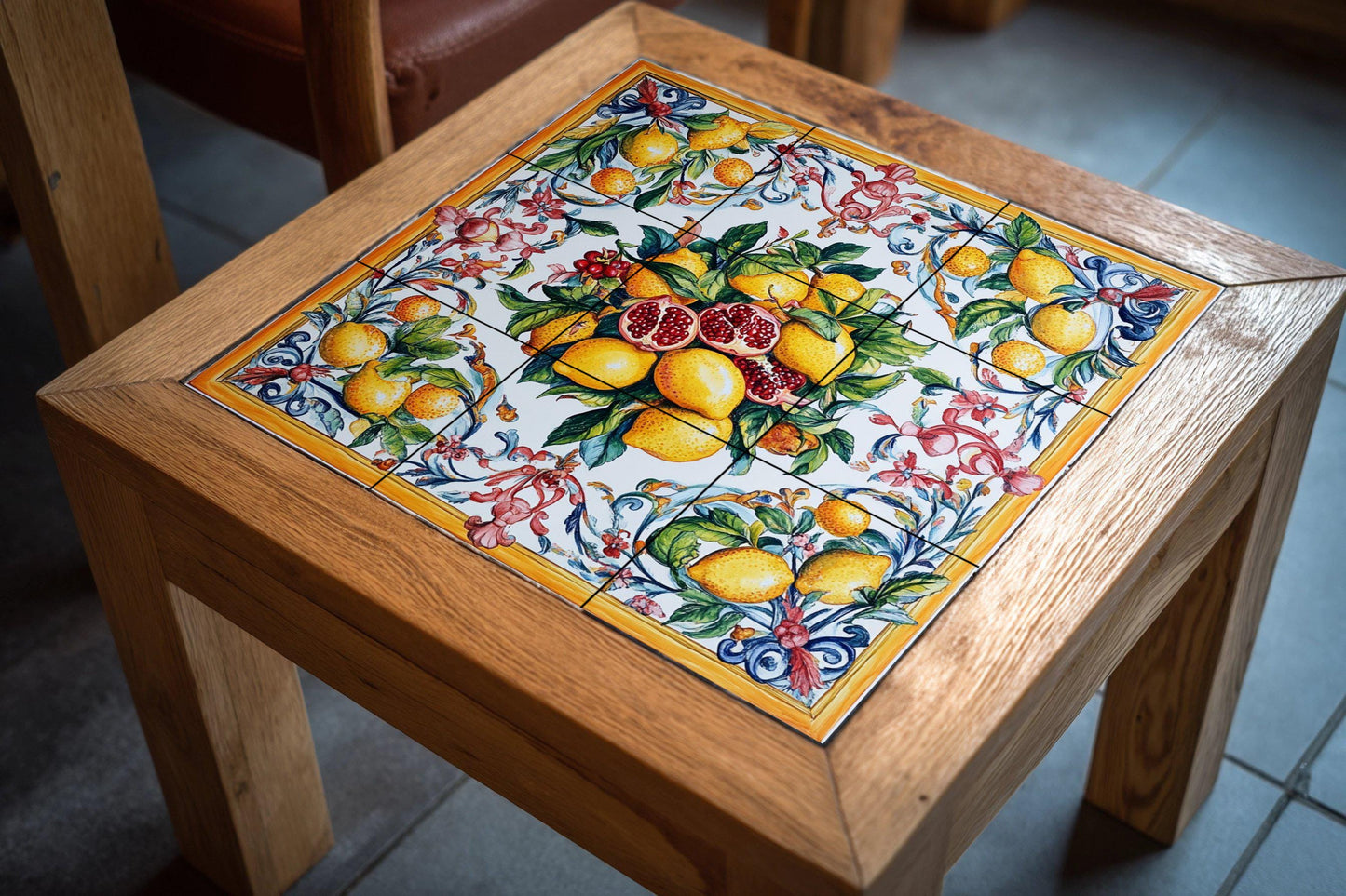 Sicilian majolica mural: lemons and pomegranates in vibrant Mediterranean colors, bordered with rococo spirals on glazed ceramic tiles.