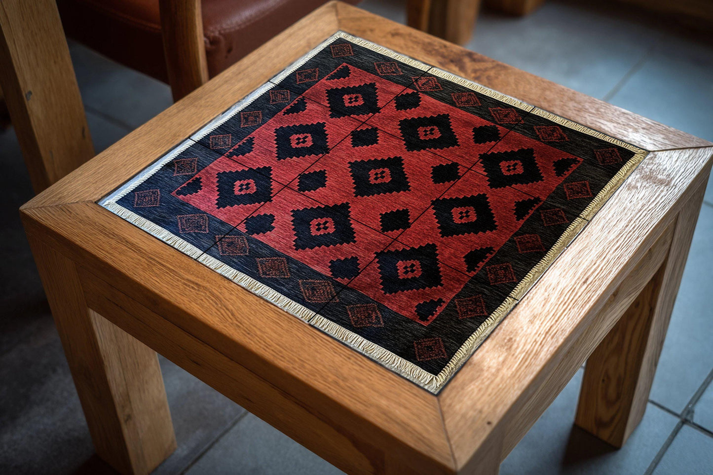 Argentine gaucho poncho ceramic mural with red and black diamond motifs and border pattern inspired by pampa weaving
