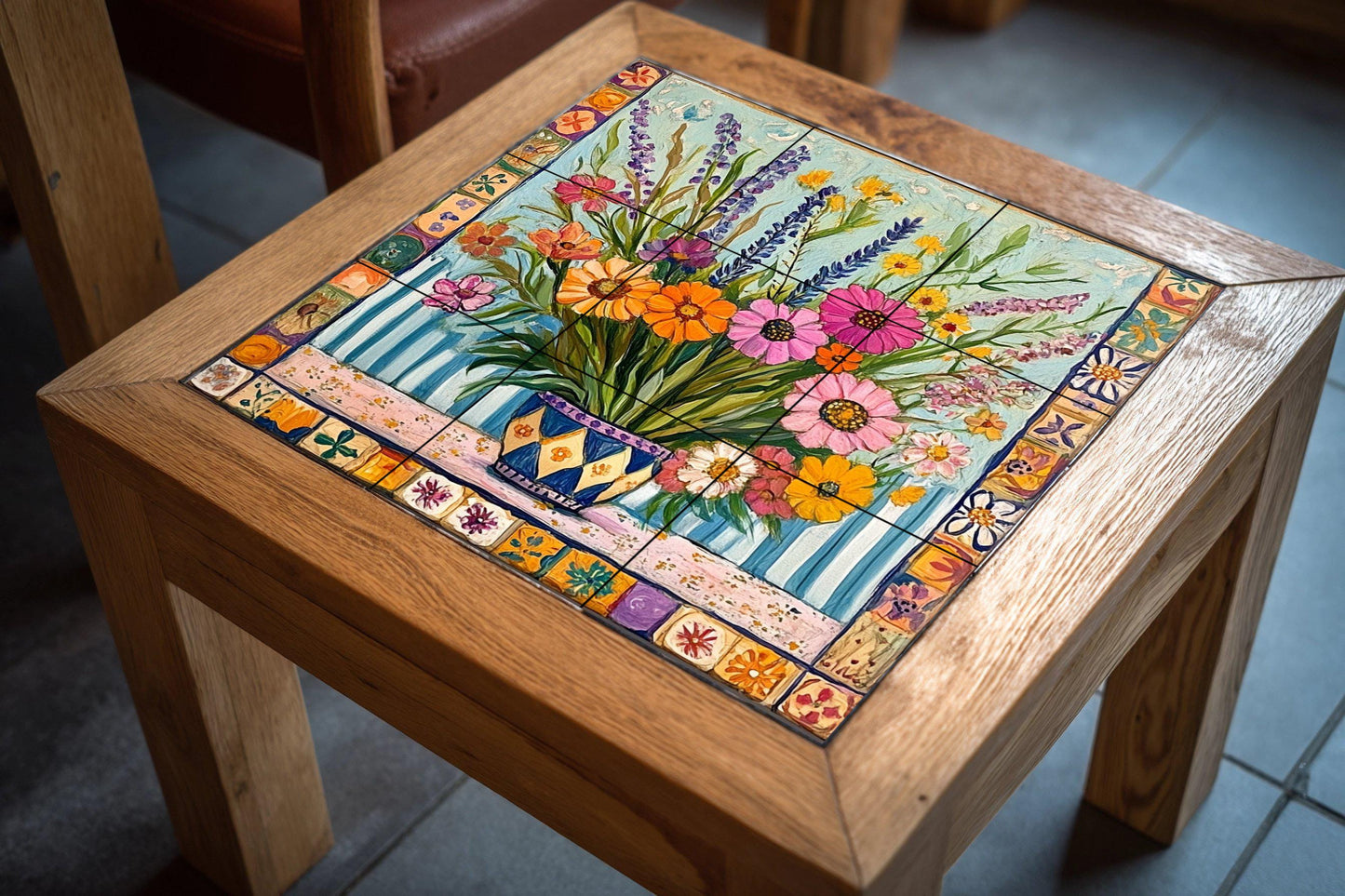 Ceramic tile mural with a colorful bouquet of wildflowers in a patterned vase, lavender, daisies, zinnias and decorative wall art with ornate border.