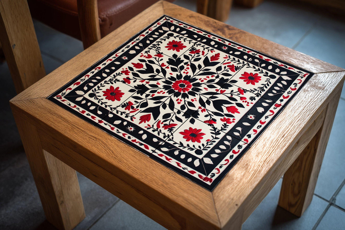 Ceramic mural with floral embroidery: symmetrical pattern of red and black flowers with ornamental border, decorative mosaic design.