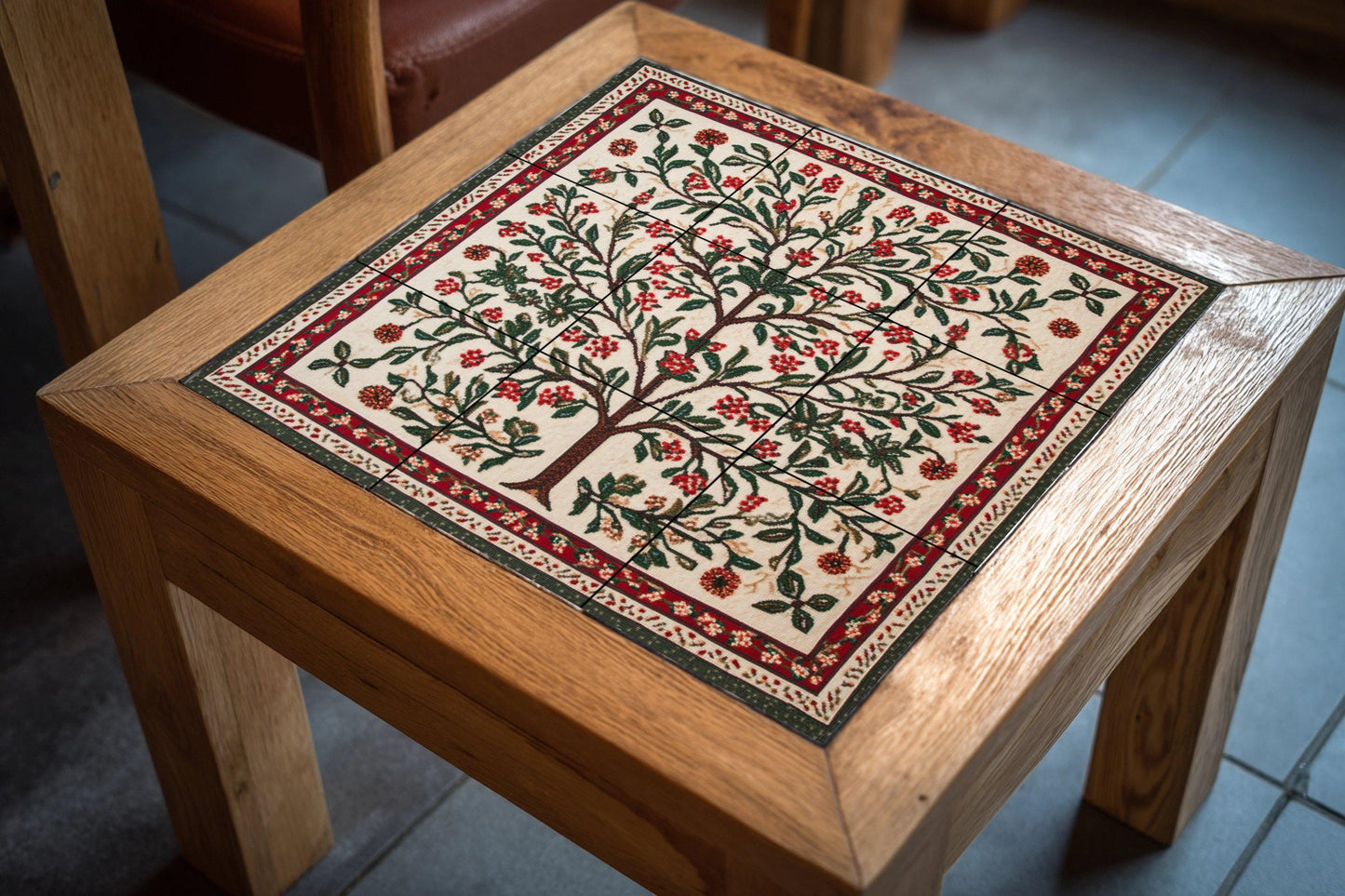 Palestinian Tatreez ceramic mural: Floral tree embroidered with olive and almond branches, red and green cross stitch pattern.