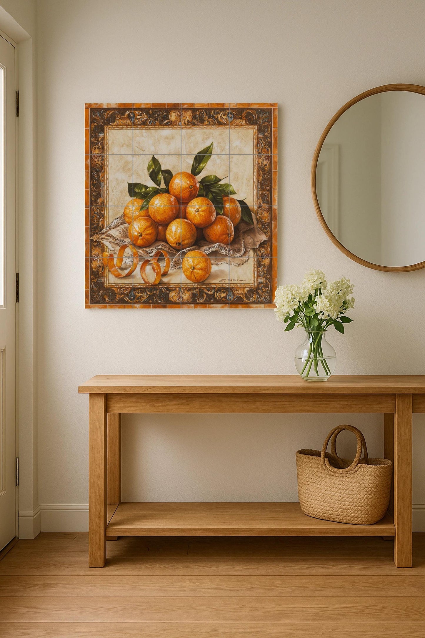 Ceramic tile mural with oranges, curled peels, lace fabric and decorative wall art panel with fruit still life and ornate baroque border.