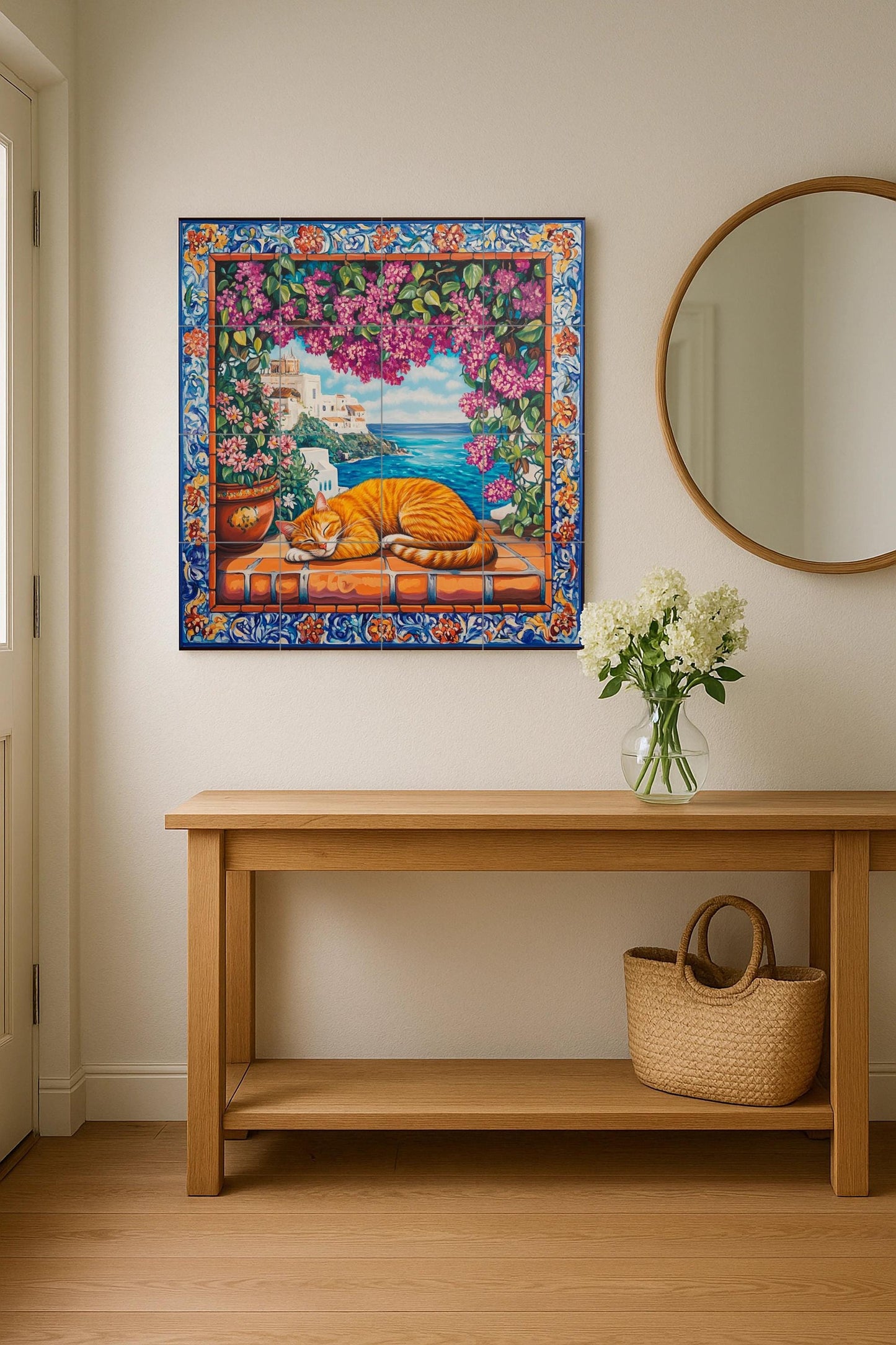 Ceramic tile mural with orange cat sleeping on terracotta tiles, view of a Mediterranean coastal village, bougainvillea and ornate floral border.