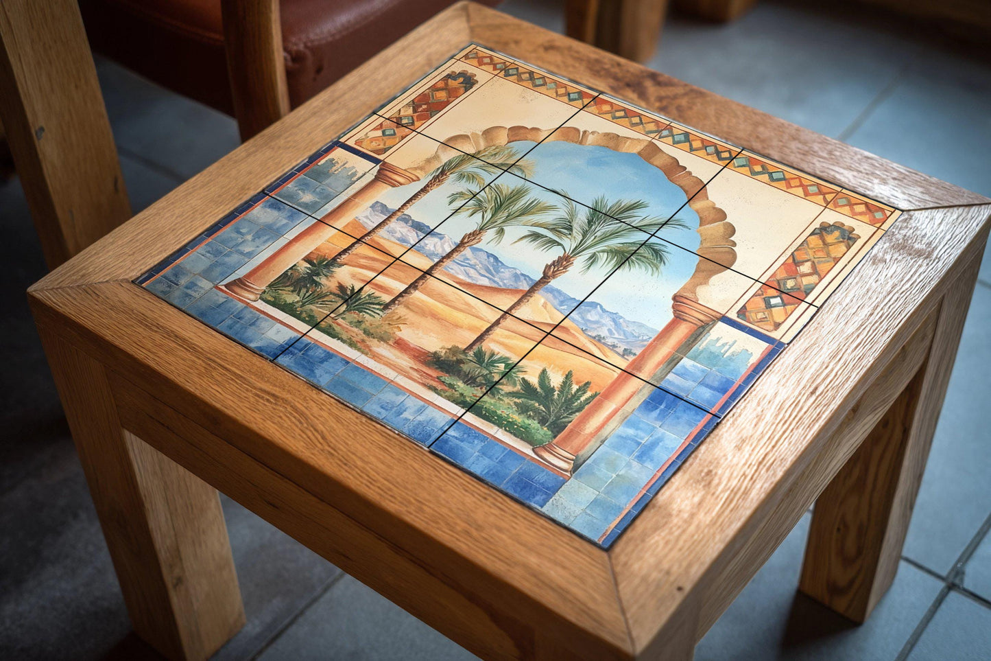Ceramic wall mural with Moorish arch, desert oasis and palm trees, Andalusian-inspired tile art with blue border, handmade exotic decor.